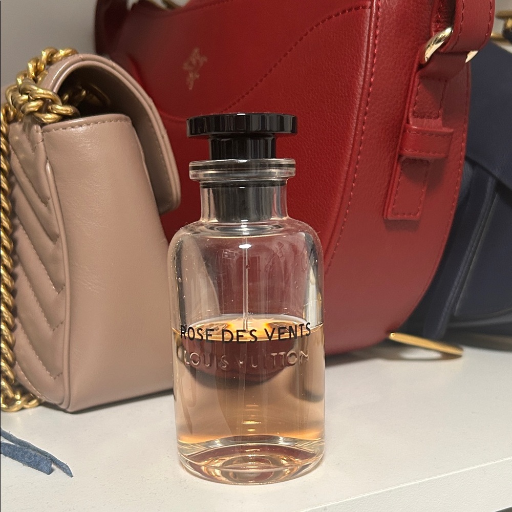 Louis Vuitton clear perfume bottle with black cap and pale amber liquid